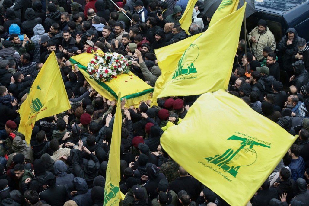 مقاتلو حزب الله وأنصاره يحضرون جنازة القائد العسكري علي الدبس الذي قُتل في غارة إسرائيلية (أ ف ب)   