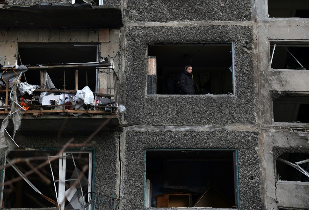 امرأة تنظر من نافذة شقة في مبنى دمره هجوم صاروخي روسي في سيليدوفي في أوكرانيافي 16 شباط/فبراير 2024 (ا ف ب)   