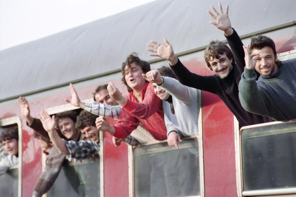    لاجئون ألبان يلوحون أثناء مغادرتهم ميناء برينديزي الإيطالي بالقطار في مارس 1991 (أ ف ب)   