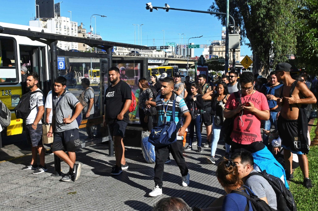 صورة نشرتها الوكالة الوطنية للأنباء الأرجنتينية تُظهر أشخاصًا ينتظرون أمام حافلة أثناء إضراب لعمال سكك الحديد في بوينوس آيرس في 21 شباط/فبراير 2024 (ا ف ب)