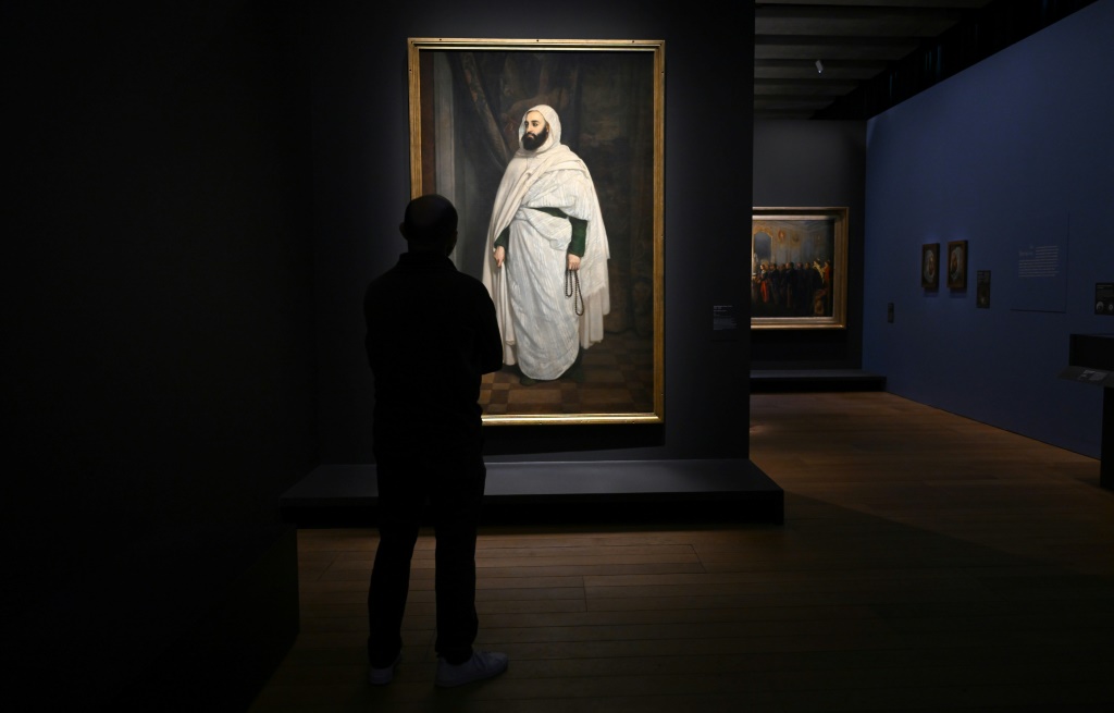 زائر أمام لوحة تمثل الأمير عبد القادر الجزائري ضمن معرض عنه في متحف حضارات أوروبا والبحر الأبيض المتوسط في مدينة مرسيليا الفرنسية في 5 نيسان/أبريل 2022 (أ ف ب)   