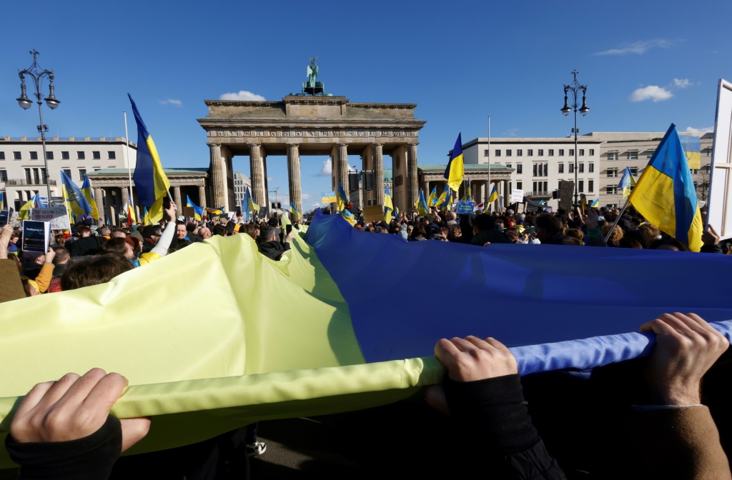 الوان العلم الاوكراني امام بوابة براندنبورغ خلال تظاهرة في برلين دعما لكييف في 24 شباط/فبراير 2023 (أ ف ب)   