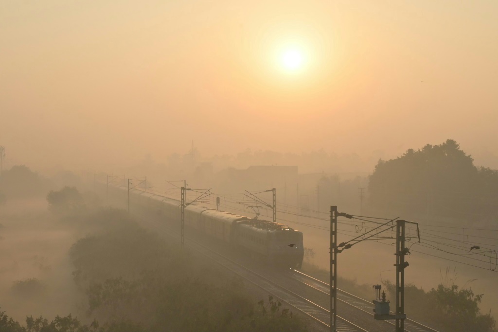 قطار يمر وسط ضباب دخاني كثيف في الهند، حيث أمرت السلطات بإجراء تحقيق في حادث قطار هارب (أ ف ب)   