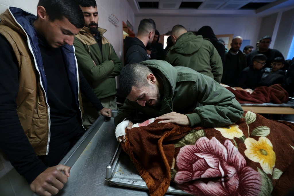 أقارب وأصدقاء الشابين أسامة زلط ومحمد بيادسة الذين قتلوا برصاص الجيش ييلقون النظرة الأخيرة على جثمانيهما في المستشفى التركي في طوباس في 27 فبراير/شباط 2024. (ا ف ب)
