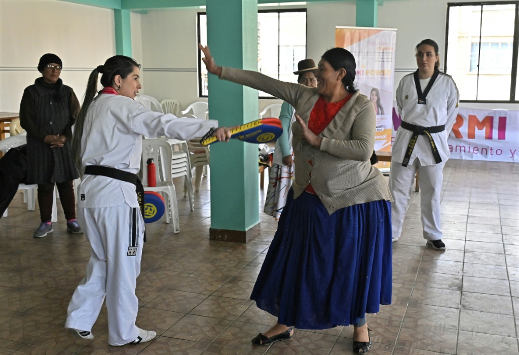 امرأة من شعب ايمارا تتدرب على فنون الدفاع عن النفس مع مدربتي التايكواندو لورا روكا (يسار) وكيمبرلي نوسا (يمين) في إل ألتو البوليفية في 21 شباط/فبراير 2024 (ا ف ب)