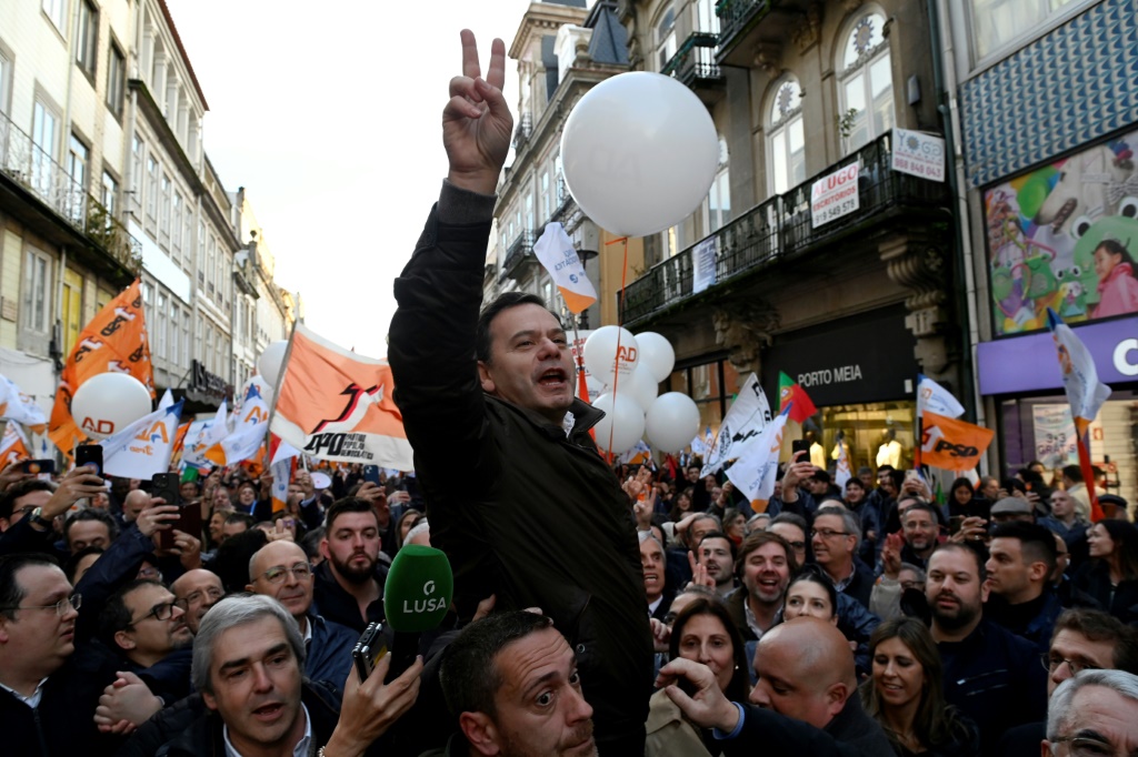 زعيم حزب التحالف الديمقراطي لويس مونتينيغرو يرفع علامة النصر خلال مسيرة حاشدة في بورتو قبل الانتخابات العامة المبكرة في البرتغال يوم الأحد (ا ف ب)
