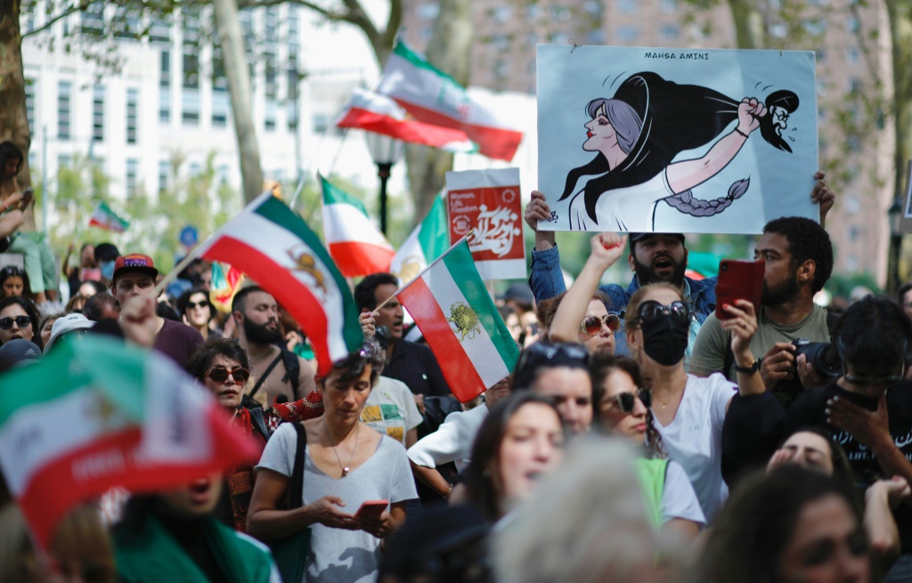 أشخاص يرفعون لافتات وأعلامًا إيرانية خلال تظاهرة في نيويورك تضامنًا مع النساء الإيرانيات في 16 أيلول/سبتمبر 2023 في الذكرى الأولى لوفاة الشابة مهسا أميني (ا ف ب)
