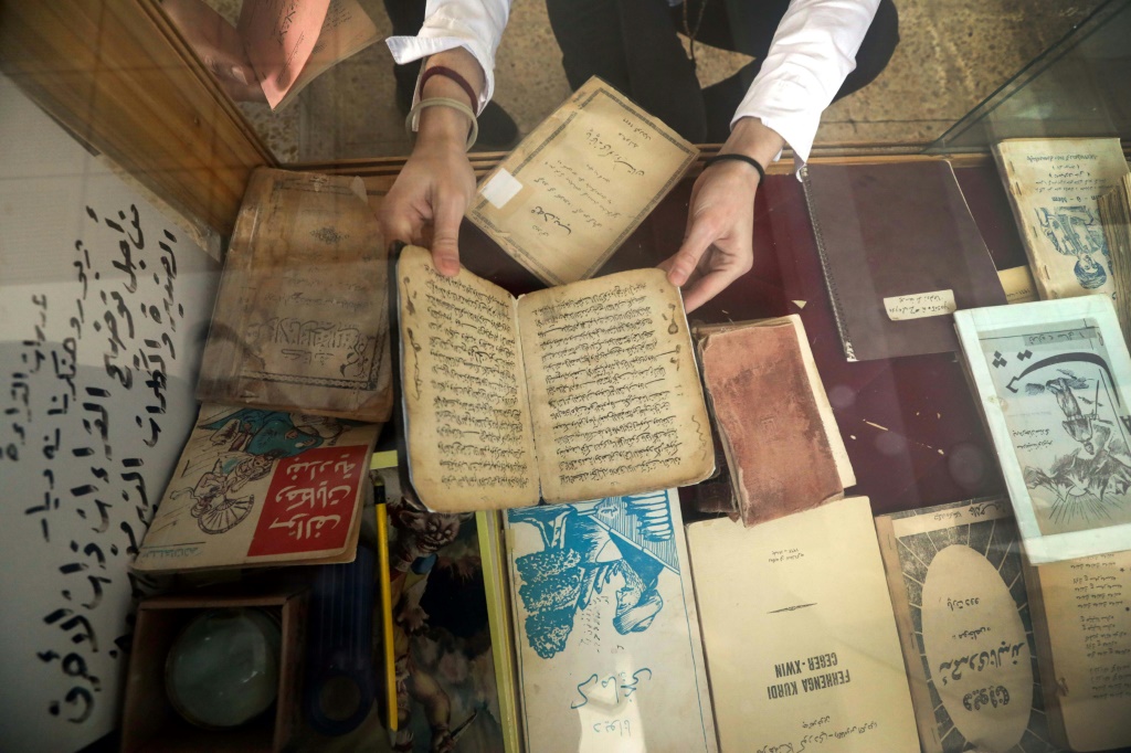 عضو في مركز كردستان للفنون والثقافة يفحص كتبا قديمة قبل حفظها الكترونيا في مكتبة دهوك في اقليم كردستان في شمال العراق في 13 شباط/فبراير 2024 (ا ف ب)
