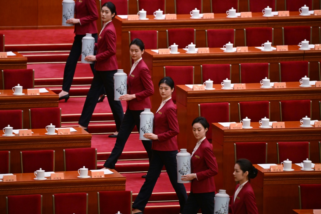 مضيفات يحملن الشاي للقادة الصينيين المجتمعين في الدورة السنوية للبرلمان، في بكين الأحد 10 آذار/مارس 2024 (ا ف ب)