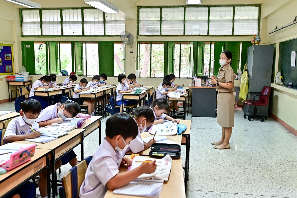 تلامذة يضعون كمامات خلال تلقيهم حصص تعليم في قاعة مفتوحة النوافذ في بانكوك في 22 كانون الثاني/يناير 2024 (ا ف ب)