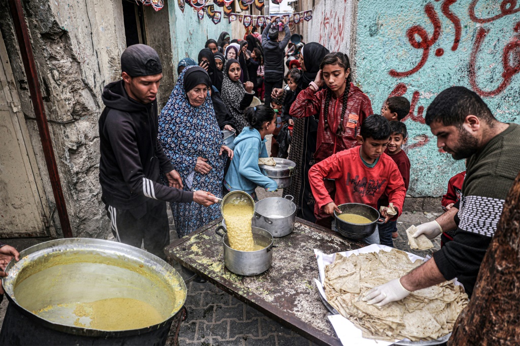 طابور من النازحين الفلسطينيين الذين ينتظرون الحصول على طعام قبل افطار رمضان في مدينة رفح بجنوب قطاع غزة في 16 آذار/مارس 2024 (ا ف ب)   