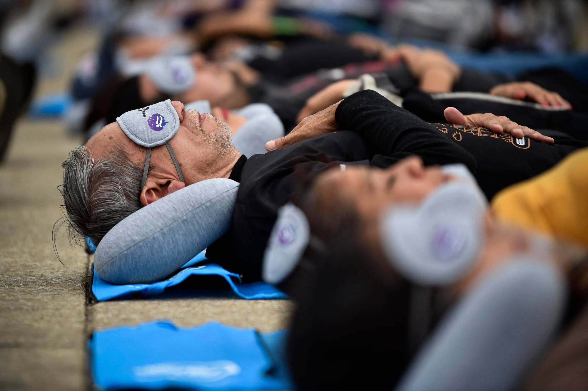 مشاركون يستمتعون بقيلولة أثناء حضورهم حدث يوم النوم العالمي في مكسيكو سيتي (أ.ف.ب)