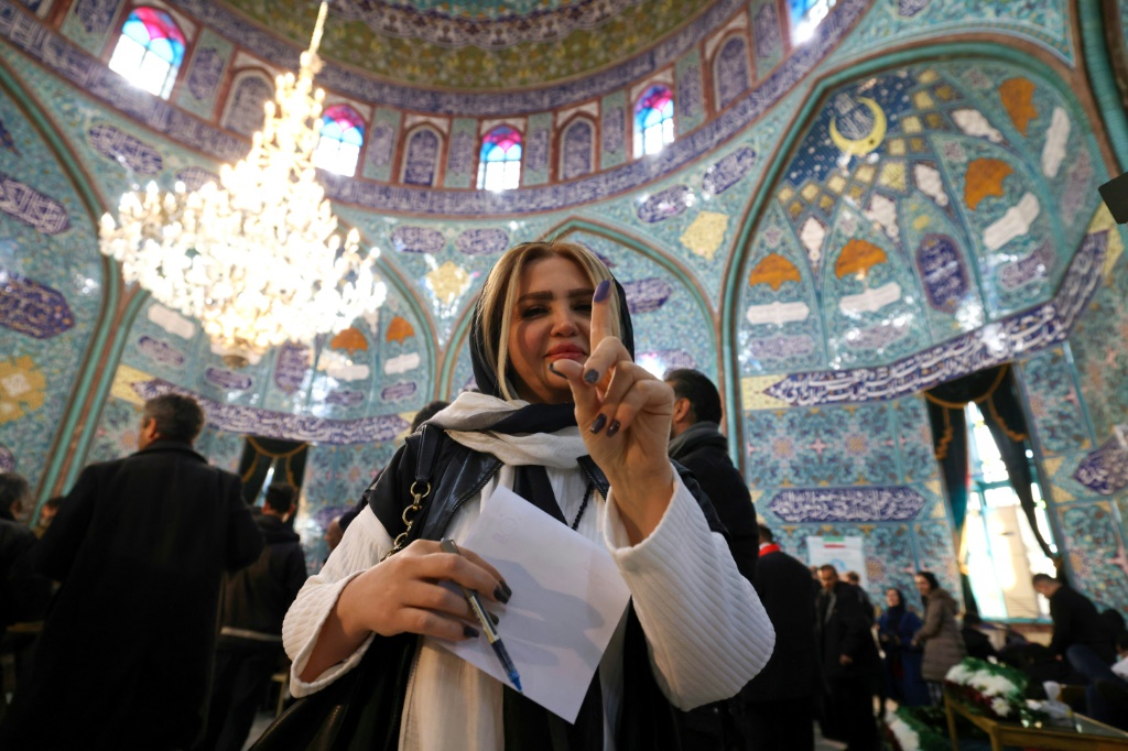إيرانية تظهر الحبر على إصبعها بعد الإدلاء بصوتها في مركز اقتراع في طهران خلال انتخابات مجلس الشورى ومجلس خبراء القيادة في 1 آذار/مارس 2024 (ا ف ب)