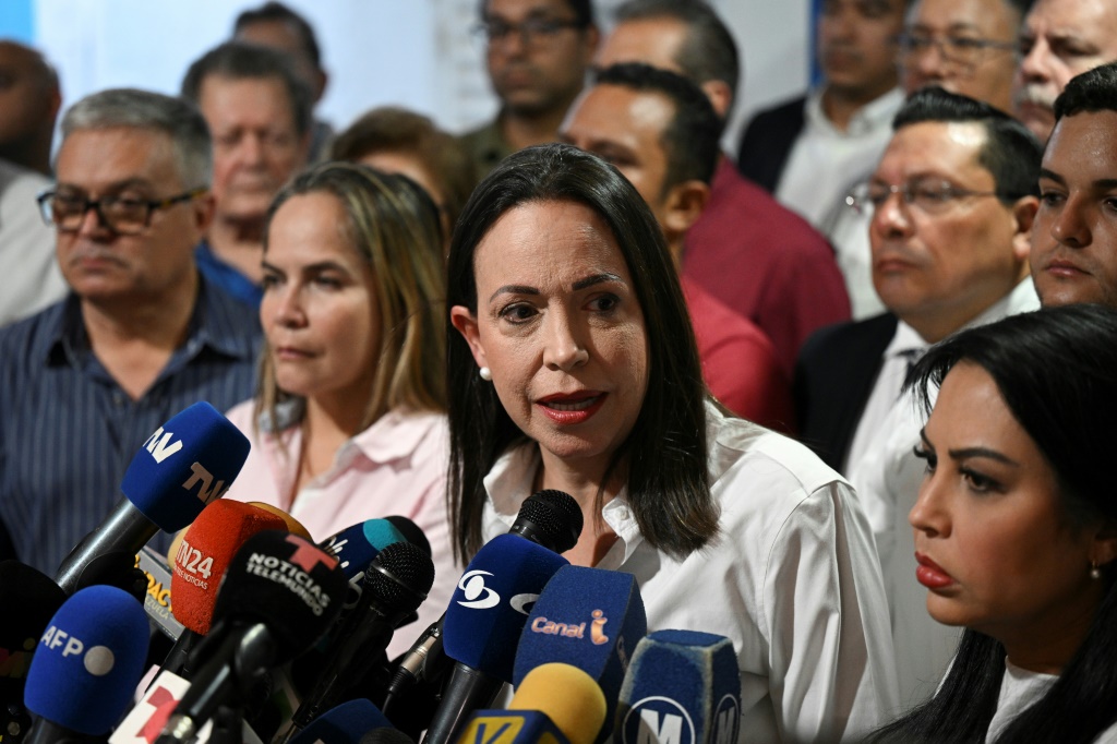 اعتقلت السلطات الفنزويلية اثنين من كبار مساعدي زعيمة المعارضة الفنزويلية ماريا كورينا ماتشادو (في الوسط) في الفترة التي سبقت الانتخابات الرئاسية في البلاد (ا ف ب)