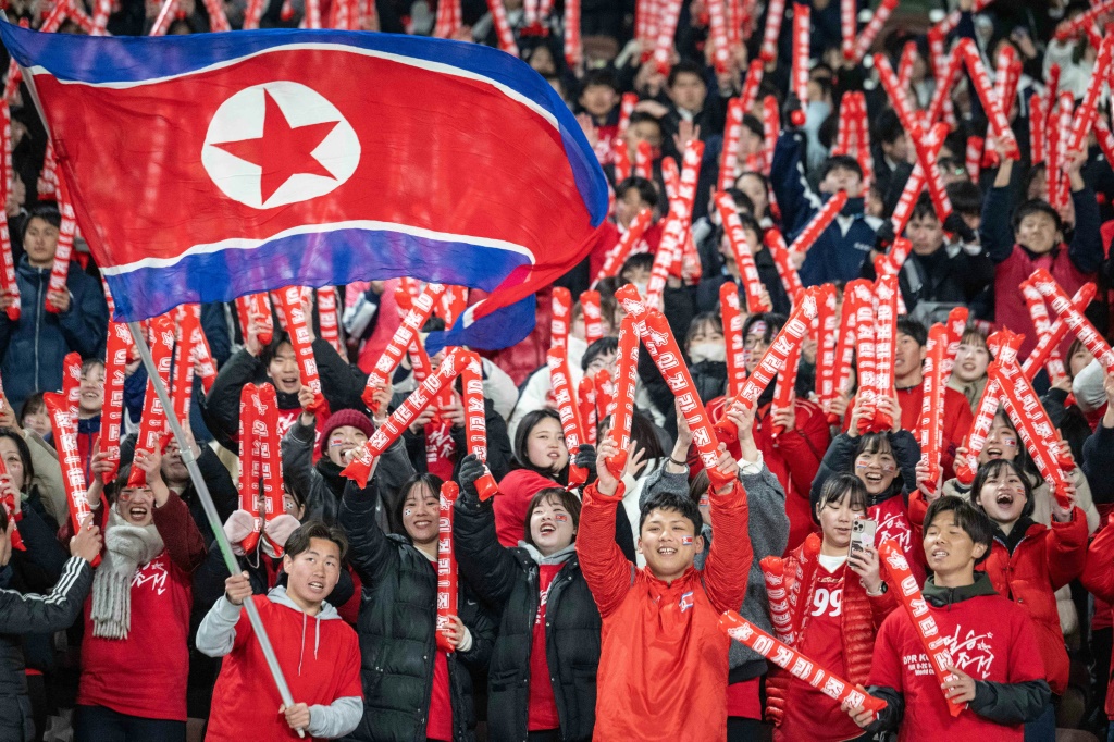 مشجعو كوريا الشمالية يهتفون قبل مباراة تصفيات كأس العالم في طوكيو (أ ف ب)   