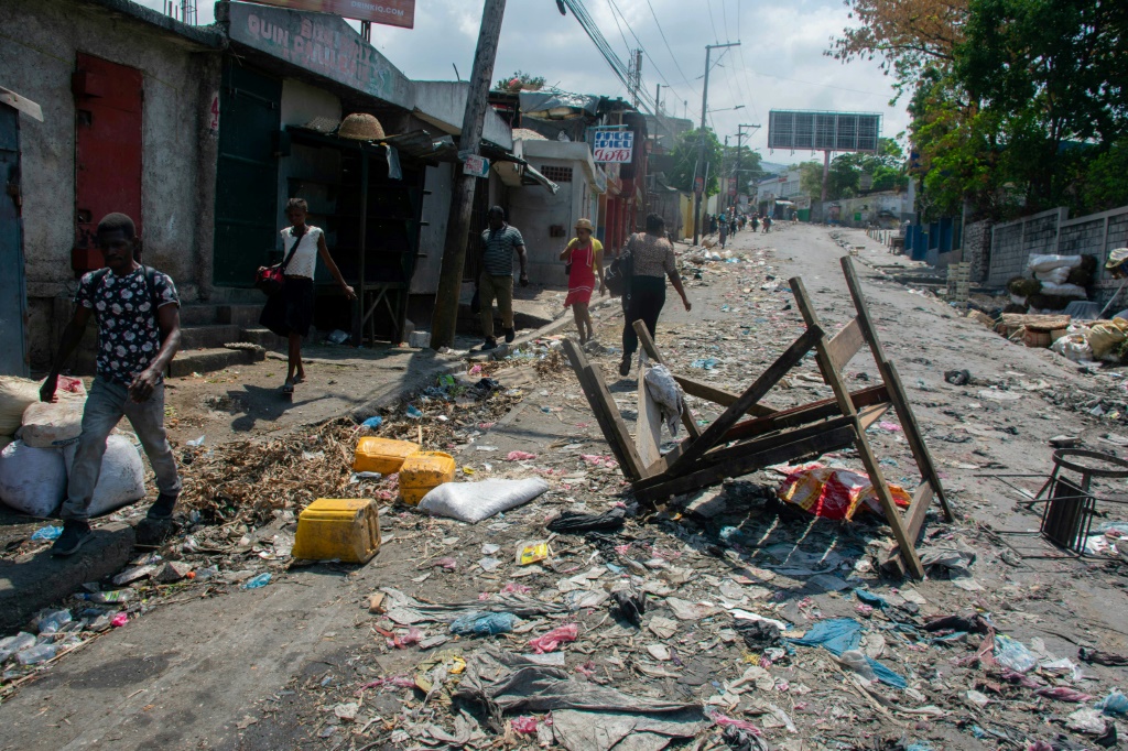 الهايتيون يسيرون أمام حاجز في 20 مارس 2024 (أ ف ب)   