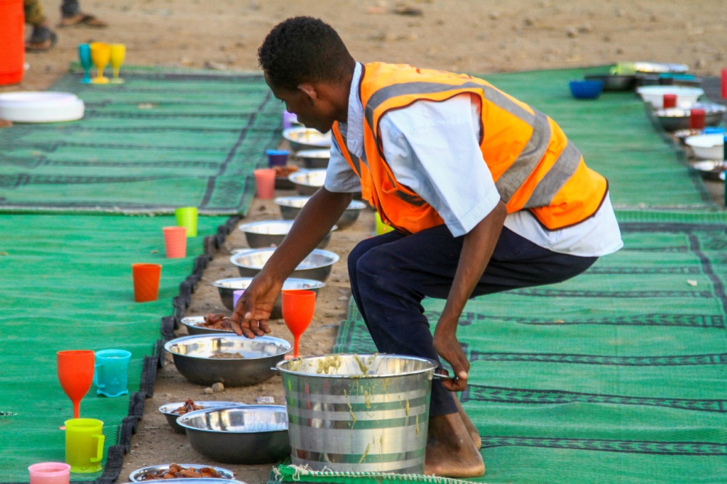 متطوع يحضر الطعان لنازحين في القضارف في الوسدان في 13 آذار/مارس 2024. (ا ف ب)