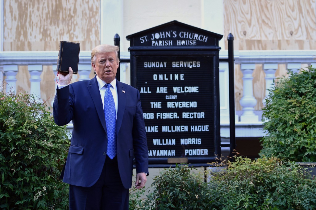 الرئيس الأمريكي آنذاك دونالد ترامب يحمل الكتاب المقدس خارج كنيسة القديس يوحنا الأسقفية بالقرب من البيت الأبيض في يونيو 2020 بعد طرد المتظاهرين السلميين من المنطقة (أ ف ب)   