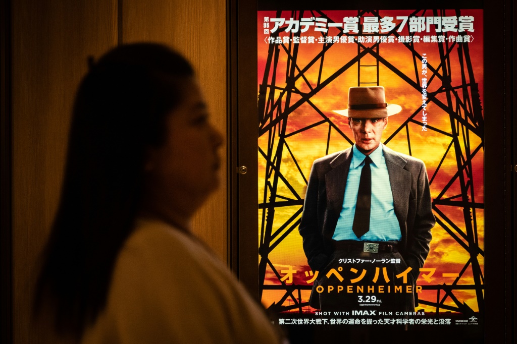 امرأة تمر في 29 آذار/مارس 2024 أمام ملصق لفيلم "أوبنهايمر" في طوكيو (ا ف ب)