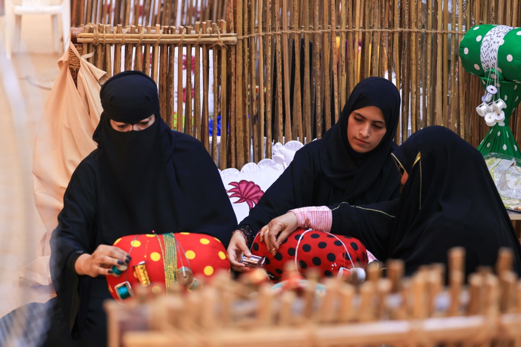 نساء إماراتيات ينسجن الخيوط بطريقة حرفة التلي خلال مهرجان تراثي سنوي في منطقة العين في إمارة أبوظبي في 10 تشرين الثاني/نوفمبر 2023 (ا ف ب)