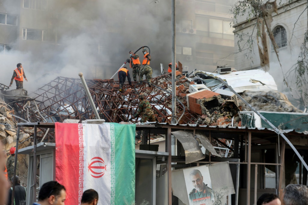 فرق إنقاذ وطوارئ تحاول إخماد النيران بعد ضربة على مبنى القنصلية الإيرانية في العاصمة السورية دمشق في الأول من نيسان/أبريل 2024 (أ ف ب)   