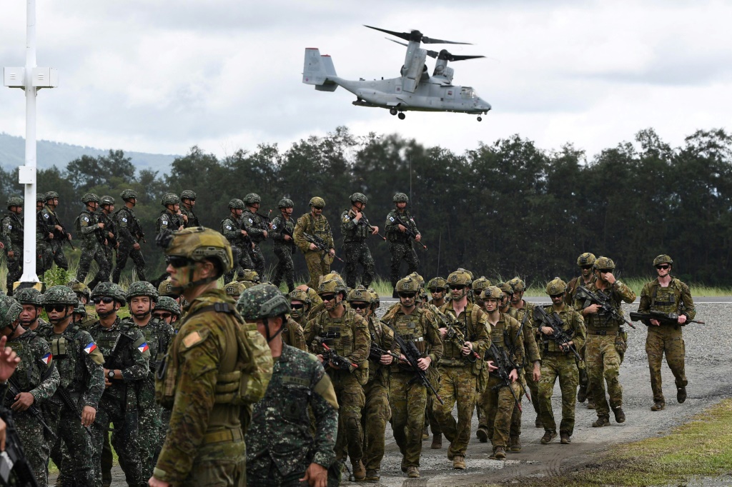جنود فلبينيون وأستراليون يسيرون في تشكيل خلال التدريب العسكري ألون 2023، وهو تدريب هبوط برمائي مشترك (ا ف ب)