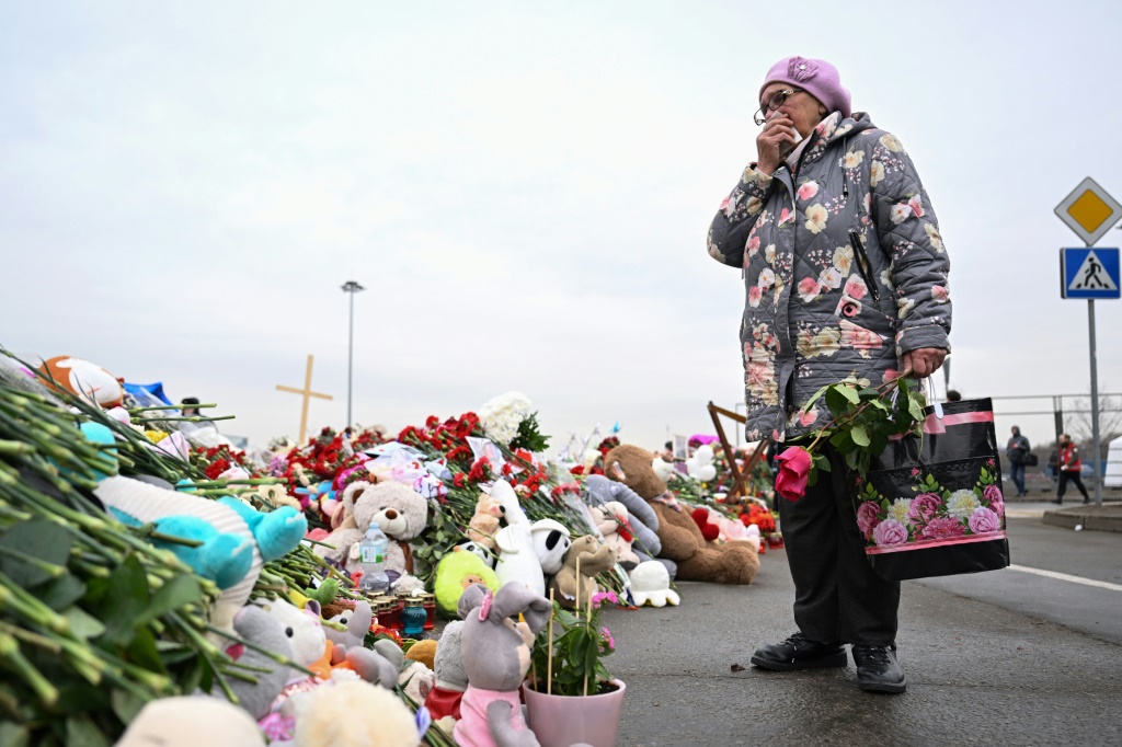    امرأة تقف عند نصب تذكاري مستحدث لضحايا هجوم موسكو في 29 آذار/مارس 2024 (أ ف ب)   