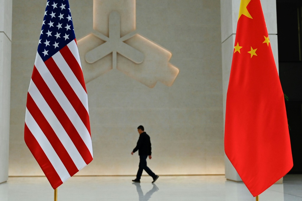 علم الولايات المتحدة والصين على بنك الشعب الصيني قبل وصول وزيرة الخزانة الأمريكية جانيت يلين إلى مقر البنك المركزي في بكين (أ ف ب)   