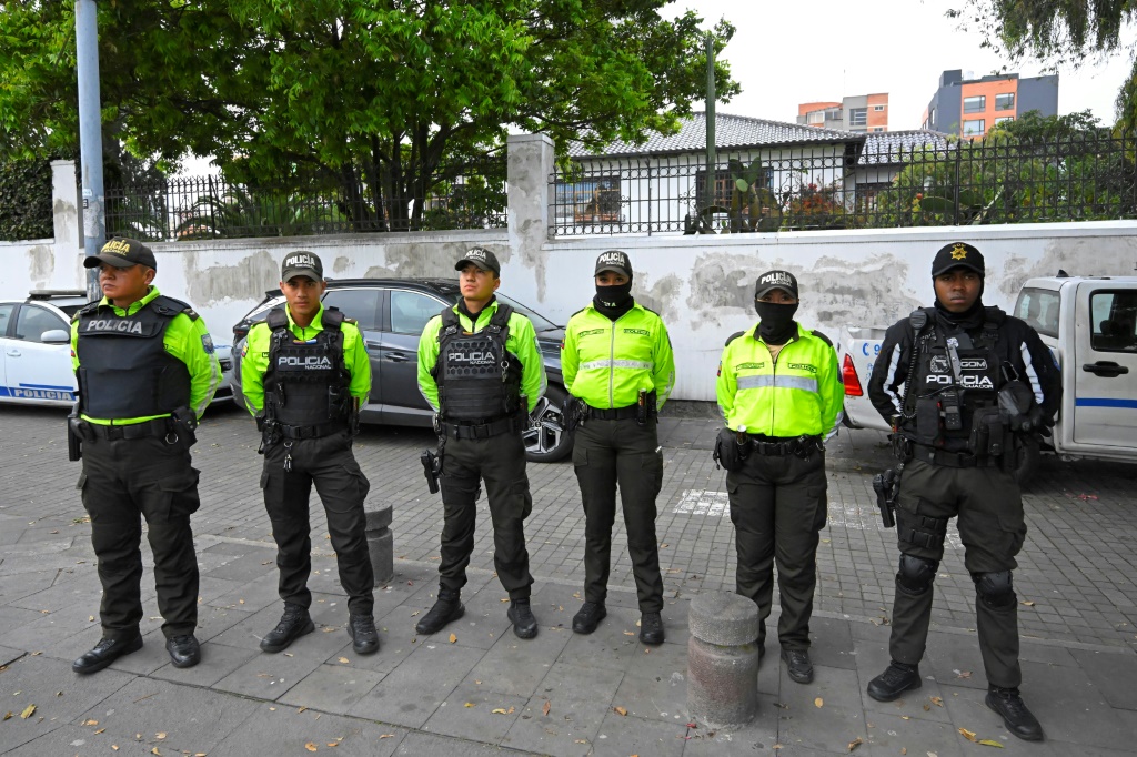 ضباط الشرطة يقفون خارج السفارة المكسيكية في كيتو (أ ف ب)   