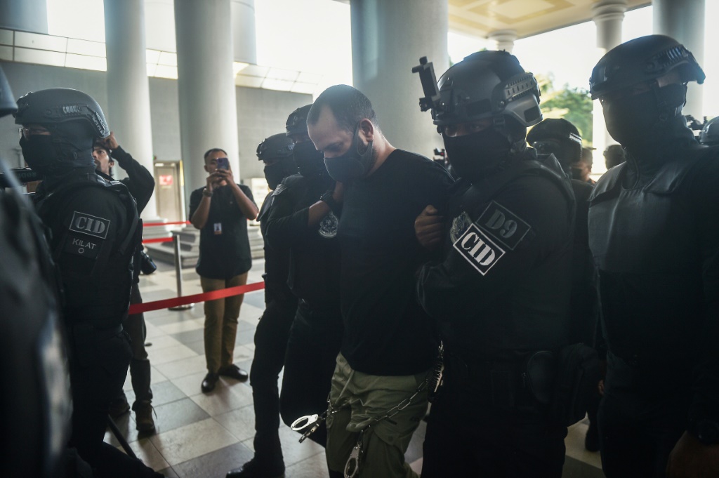الإسرائيلي شالوم أفيتان (وسط) أثناء اقتياده من قبل الشرطة الماليزية لدى وصوله إلى محكمة في كوالالمبور بتاريخ 12 نيسان/أبريل 2024 (ا ف ب)