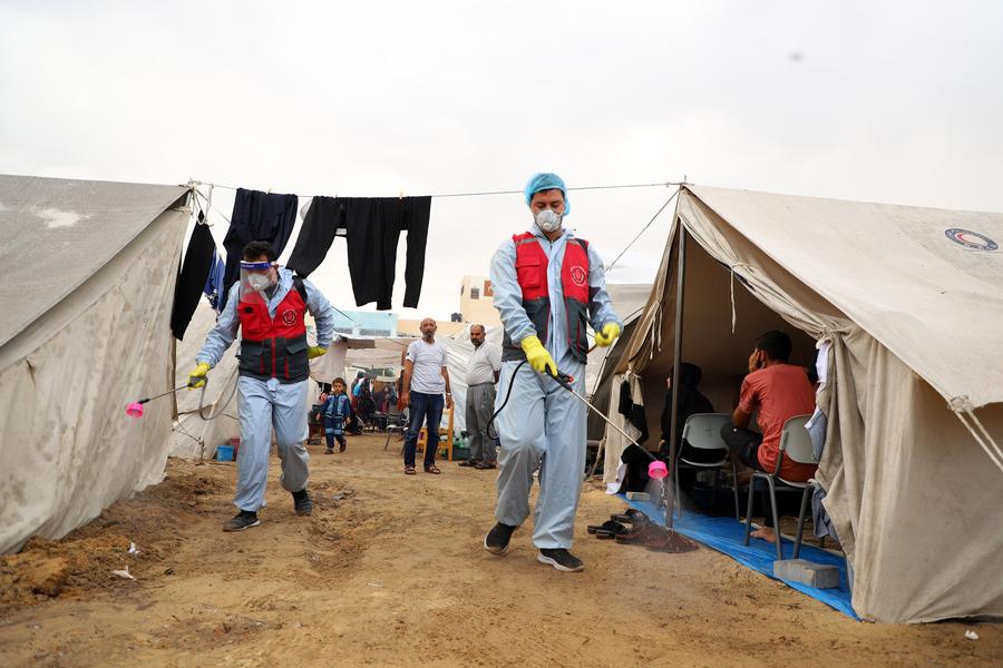 في الصورة الملتقطة يوم 12 نوفمبر 2023، عمال يعقمون مخيمات مؤقتة في مدينة خان يونس جنوبي قطاع غزة. (شينخوا)