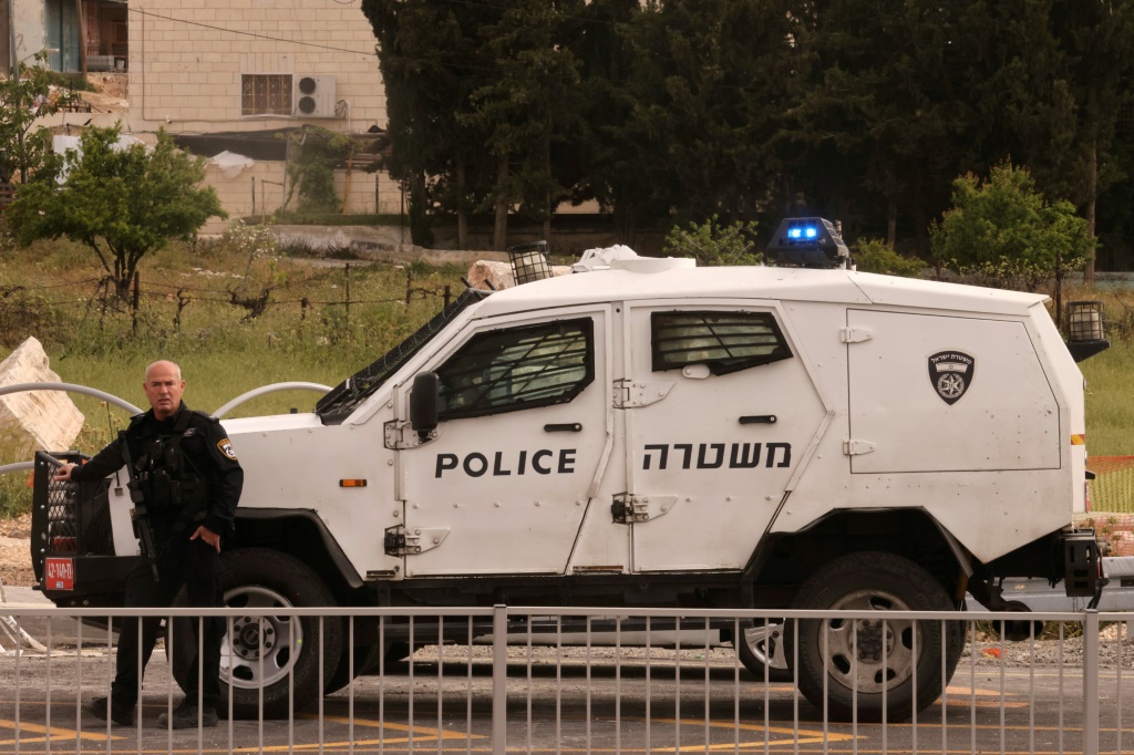 شرطي إسرائيلي يطوق منطقة مفرق بيت عينون بعد الحادث الدامي الأخير في الضفة الغربية التي تحتلها إسرائيل (ا ف ب)