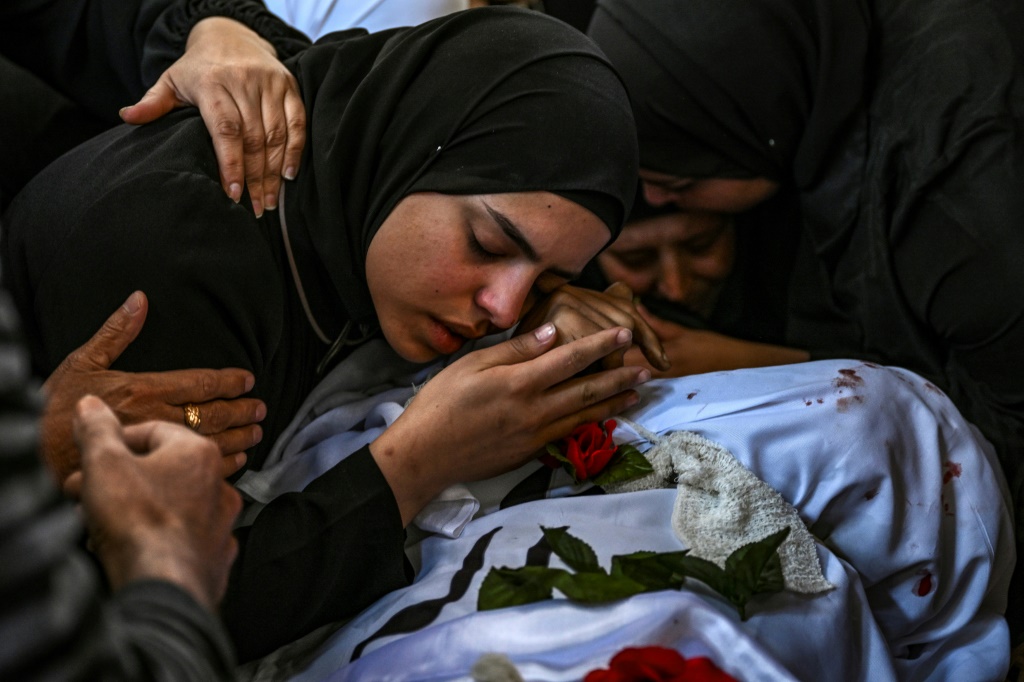 امرأة تبكي على جثة رجل قُتل برصاص الجيش الإسرائيلي لدى مداهمته مخيم نور شمس للاجئين الفلسطينيين في الضفة الغربية المحتلة خلال جنازته في 21 نيسان/أبريل 2024 (أ ف ب)   