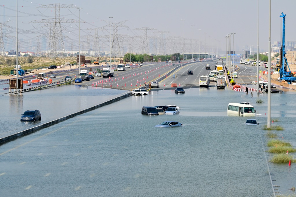    تقطعت السبل بالسيارات في أحد الشوارع التي غمرتها المياه في دبي بعد هطول أمطار غزيرة الأسبوع الماضي (أ ف ب)   