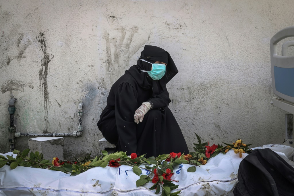 امرأة تبكي قرب جثمان انتشل من حفرة قرب مجمع ناصر الطبي في خان يونس جنوب غزة (ا ف ب)