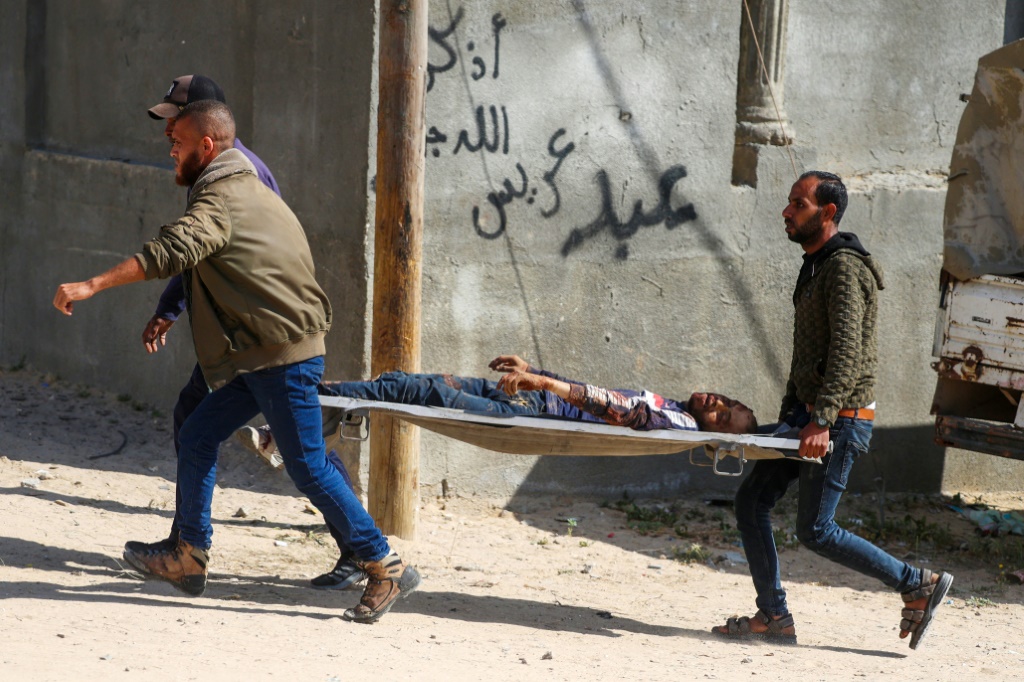 فلسطينيون ينقلون رجلا على حمالة بعد قصف إسرائيلي على مخيم النصيرات وسط قطاع غزة في 12 نيسان أبريل 2024 (ا ف ب)