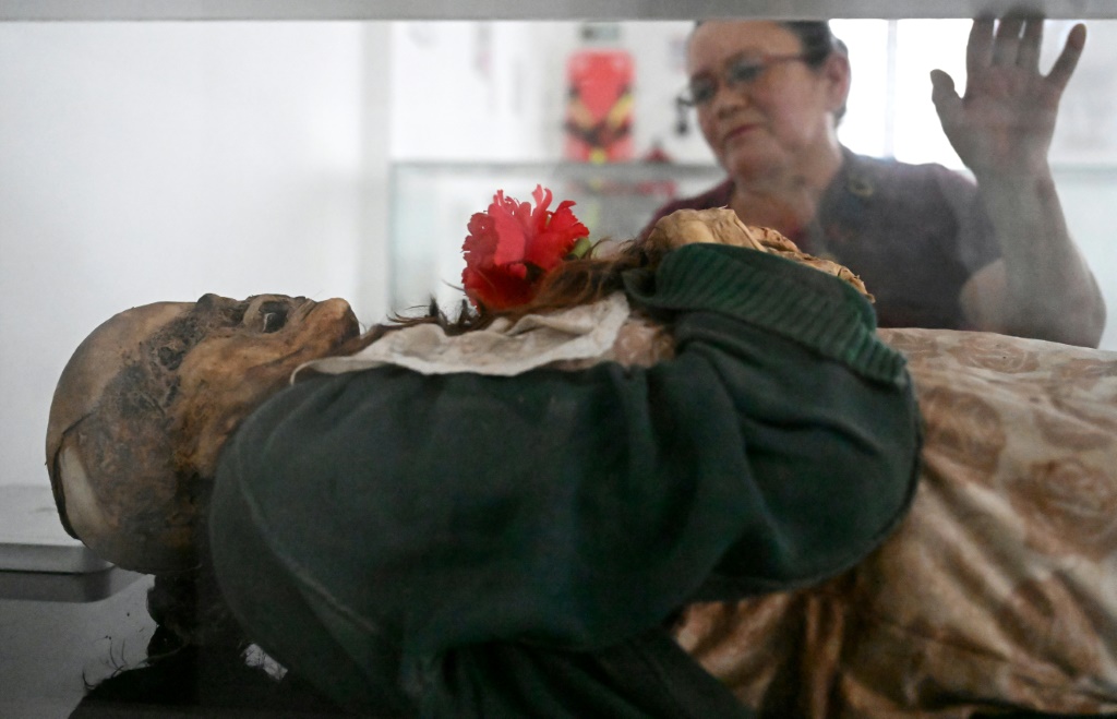 كلوفيسنيريس بيخارانو أمام جثة والدتها ساتورنينا توريس التي توفيت عام 1993، في متحف المومياوات في سان برناردو الكولومبية بتاريخ 10 نيسان/ابريل 2024 (ا ف ب)