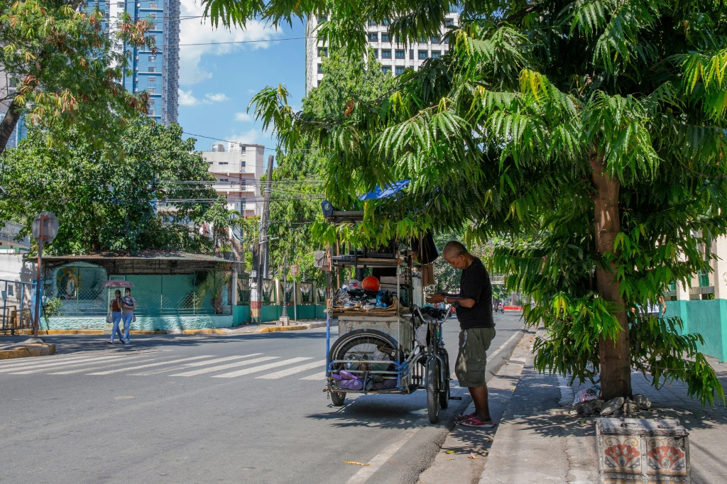 بائع متجول يتقي من الحر في ظل شجرة في مانيلا في 28 نيسان/أبريل 2024 (ا ف ب)